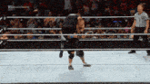 a wrestler is being lifted in the air by another wrestler in a crowded ring