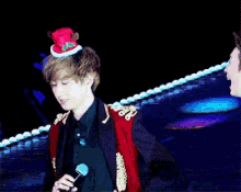 a man wearing a red jacket and a top hat stands next to another man
