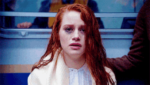 a woman with red hair has a black spot on her eye