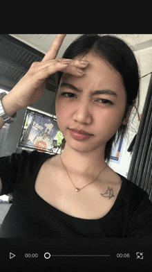 a woman with a bird tattoo on her chest is making a face