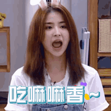 a woman wearing bunny ears and overalls is making a funny face with the words " eat " below her