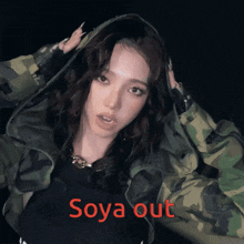 a woman wearing a camouflage jacket with the words soya out written on it