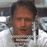 a man wearing headphones is talking into a microphone and making a funny face .