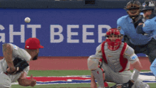 a baseball game is being played in front of a sign that says light beer