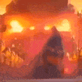 a blurred image of a person standing in front of a castle with fire coming out of it .
