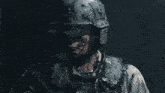 a man wearing a helmet with bullets coming out of it holds his hand up