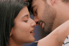 a man and a woman are kissing each other in a close up of their faces .