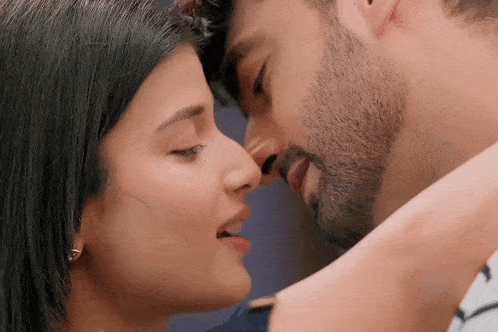 a man and a woman are kissing each other in a close up of their faces .