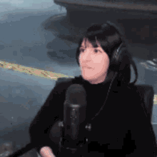 a woman wearing headphones and a microphone looks at the camera