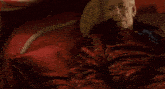 a man in a red robe is laying in bed