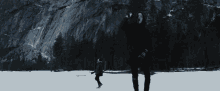 two people are ice skating on a frozen lake