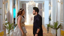 a man and a woman are standing next to each other in a hallway