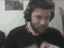 a man with a beard wearing headphones looks at the camera