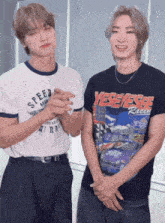 two young men standing next to each other one wearing a yeseyese racing shirt