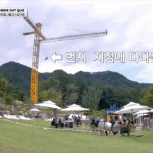 a group of people sitting under umbrellas in front of a crane that says outside out quiz