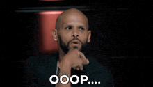a bald man with a beard and earrings says ooops