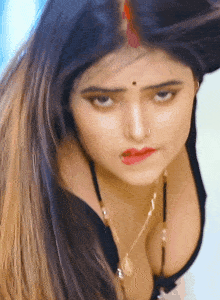 a close up of a woman 's face with a necklace on her neck