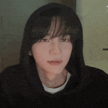 a close up of a young man wearing a black hoodie