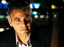 a man in a suit is looking at the camera