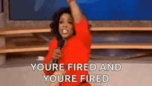 a woman in a red dress is holding a microphone in her hand and screaming .