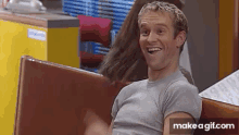 a man is sitting in a diner making a funny face and smiling .