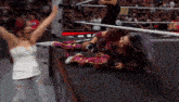 two women are wrestling in a ring and one is laying down