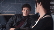 a man and a woman are sitting next to each other and talking