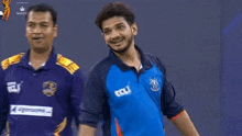two men are standing next to each other and one of them is wearing a blue shirt that says ecli .