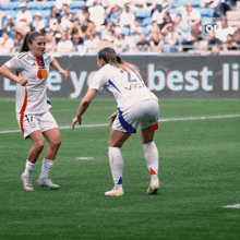 two female soccer players on a field with an ad in the background that says " best li "