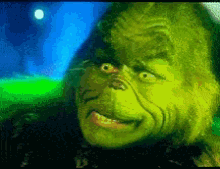 a close up of a grinch 's face with a moon in the background