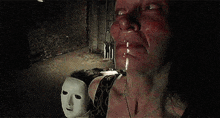 a woman is crying while holding a mask in her hand .