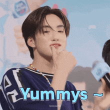 a young man wearing a blue shirt with the word yummys on the bottom