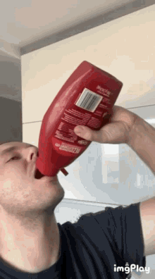 a man is drinking ketchup from a bottle with a label that says popeye