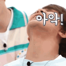 a close up of a man 's neck with korean writing on his face