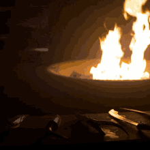 a fire pit with flames coming out of it and a few knives on a table