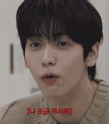 a close up of a man 's face with korean writing on the bottom