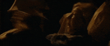a man in a suit and tie is holding a woman 's hand in the dark .