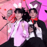 two men dressed in costumes are sitting next to each other .