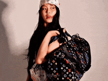 a woman holding a louis vuitton bag and a bandana
