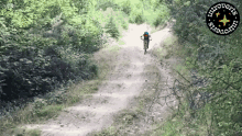a person riding a bike down a dirt road with a logo that says introverts start