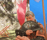 a woman holding a fan looking at her phone