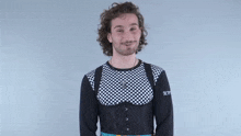 a man wearing a black and white checkered shirt is giving a middle finger