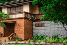 a brick house with a balcony and a lamp post outside