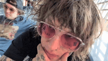 a man wearing sunglasses has a tattoo on his face that says " play "