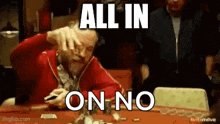 a man is sitting at a table with a bunch of cards on it and making a face .