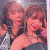 a couple of girls are posing for a picture together and one of them is giving a peace sign .