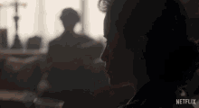 a woman in a dark room with a netflix logo on the bottom right
