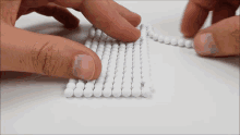 a person is holding a bunch of white beads in their hand