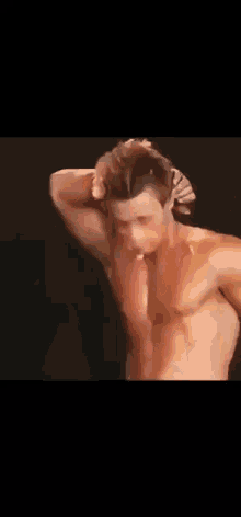 a shirtless man with a woman 's hand on his neck .