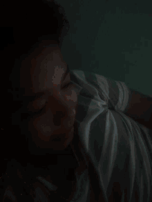 a person is laying down with their eyes closed